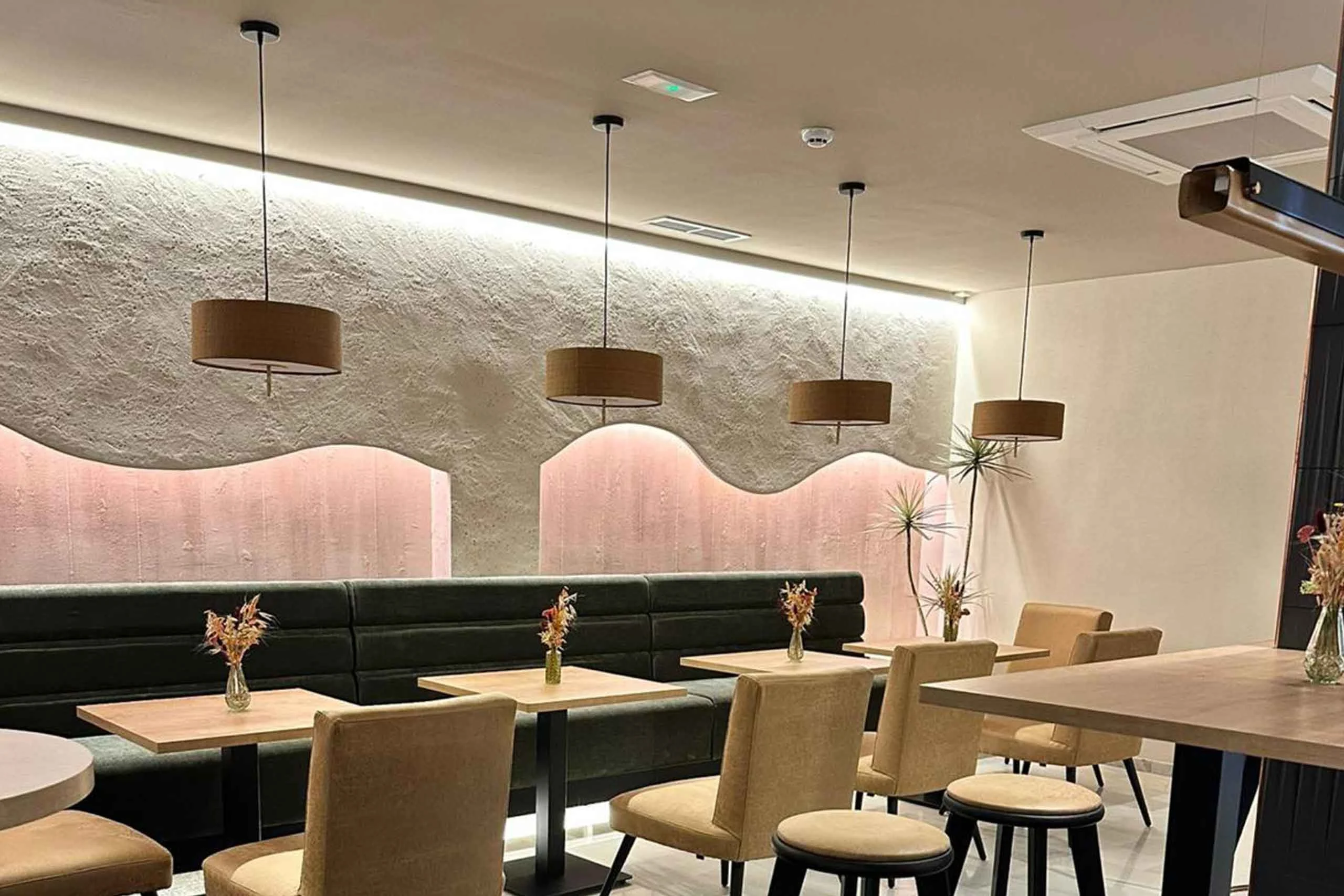 Interior de restaurante con paredes texturizadas en tonos rosados